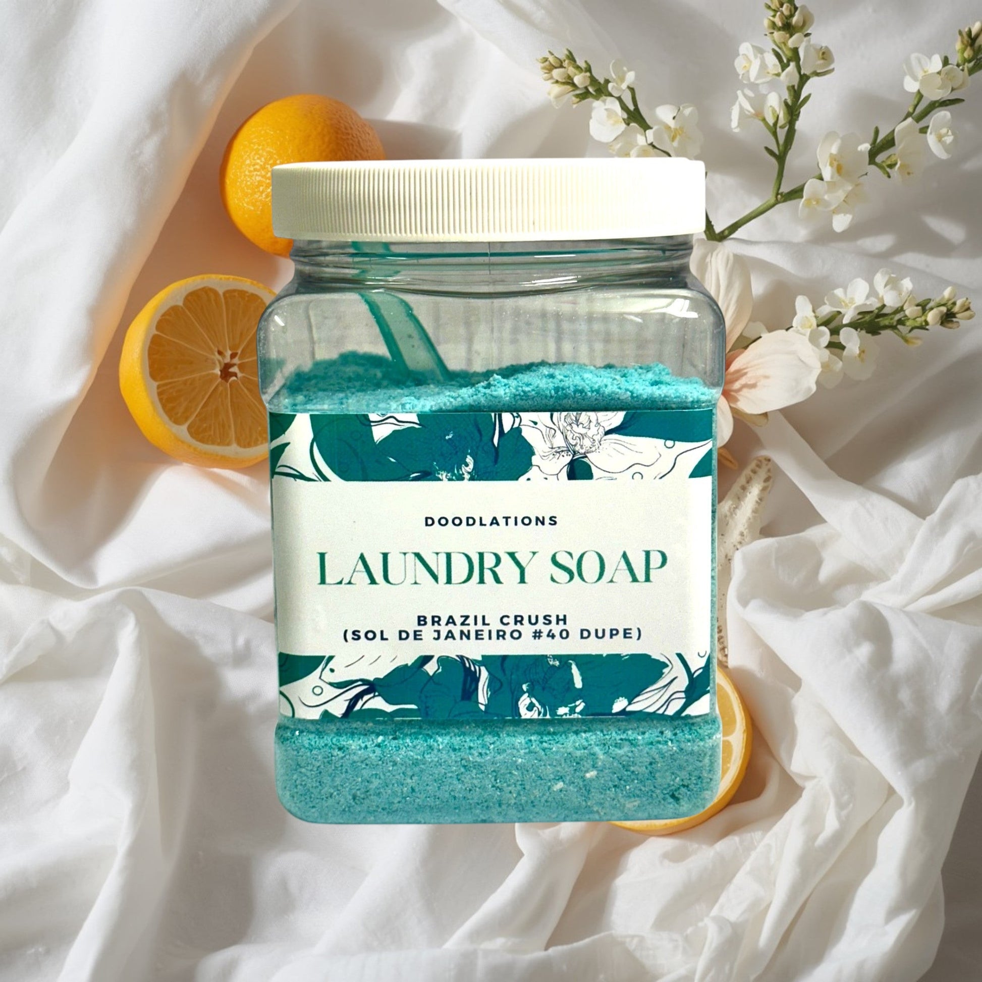Doodlations Luxury Laundry Soap in Brazilian Crush scent, a vibrant turquoise powder in a clear jar with a floral label.