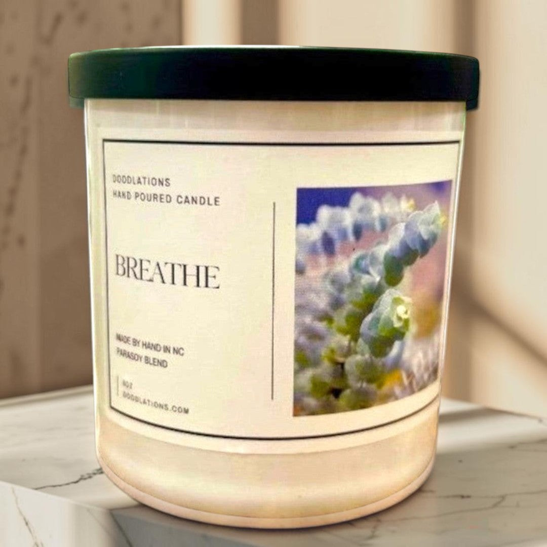Doodlations hand-poured soy wax candle labeled "Breathe" with a botanical image, promoting relaxation.