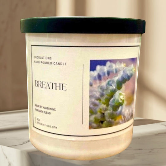 Doodlations hand-poured soy wax candle labeled "Breathe" with a botanical image, promoting relaxation.