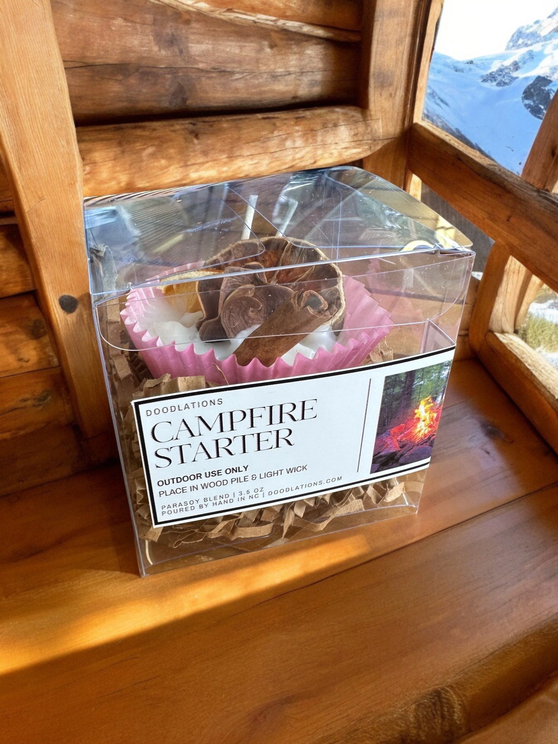 Doodlations campfire starter with cinnamon stick and dried orange slice in wax, packaged in a clear box.