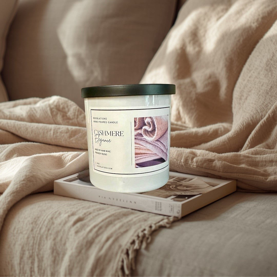 Doodlations Cashmere Elegance hand-poured candle in a white jar with a black lid, featuring a cozy cashmere texture image.