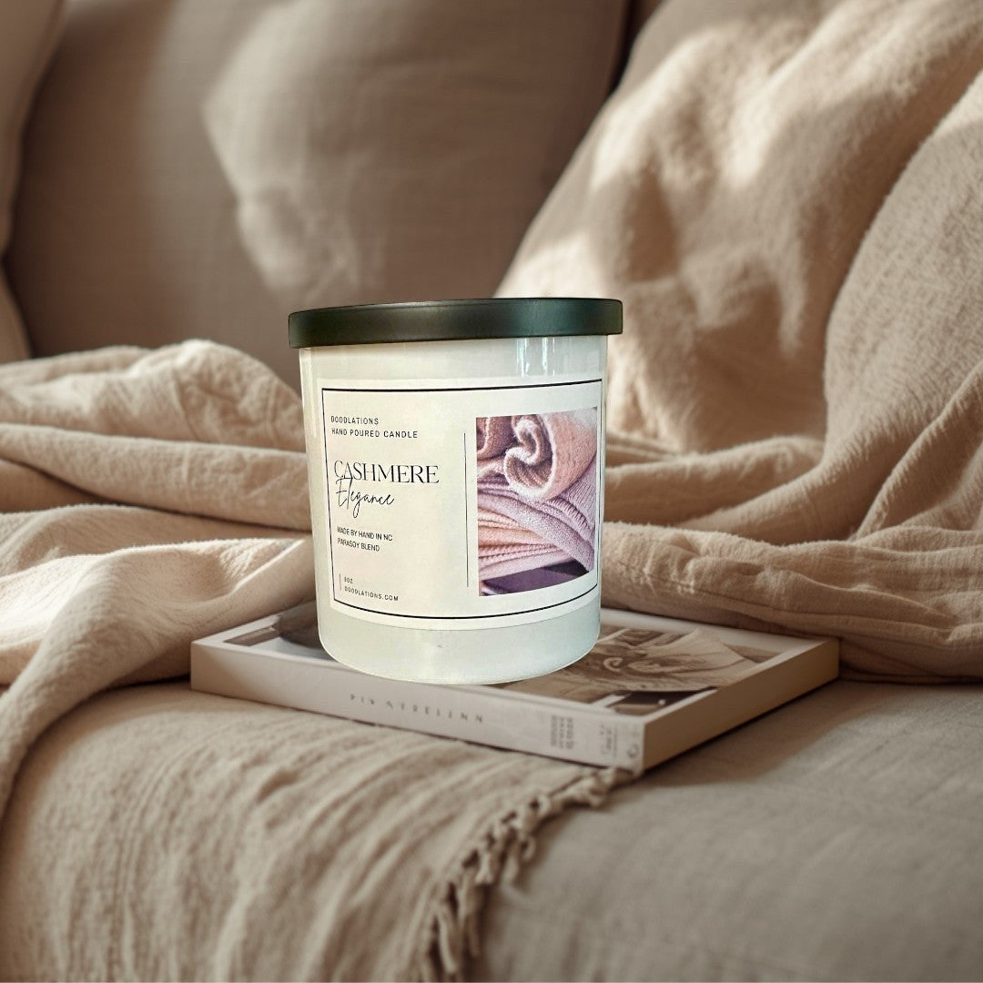 Doodlations Cashmere Elegance hand-poured candle in a white jar with a black lid, featuring a cozy cashmere texture image.