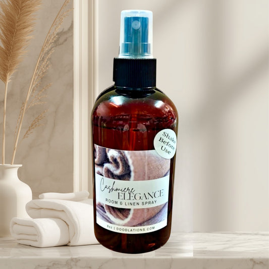 Doodlations Coffee Bar & Boutique Cashmere Elegance room and linen spray in amber bottle with a warm, inviting scent.