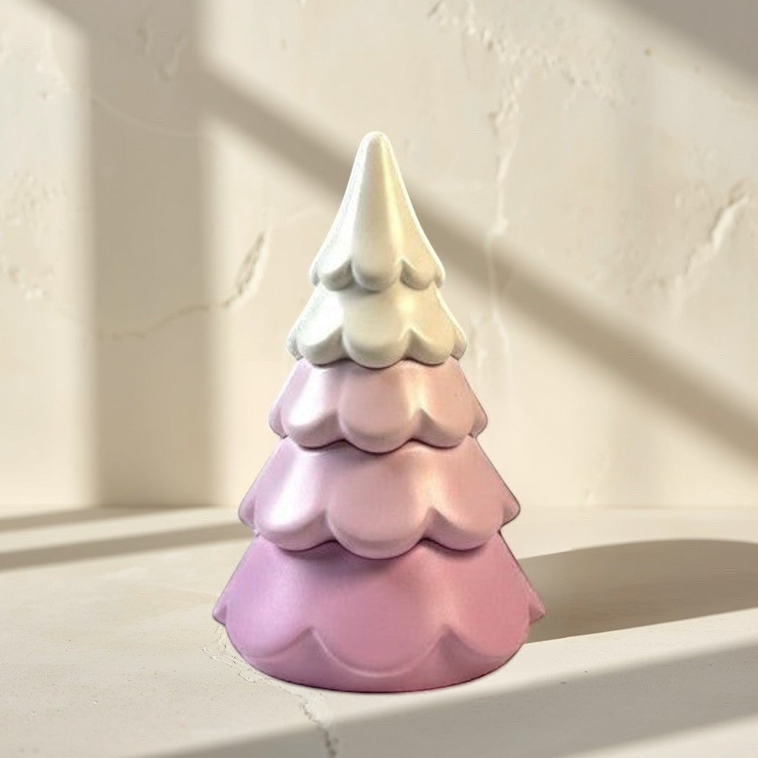 Doodlations 3-Tier Christmas Tree candle in pastel pink concrete with a white top. Modern holiday decor.