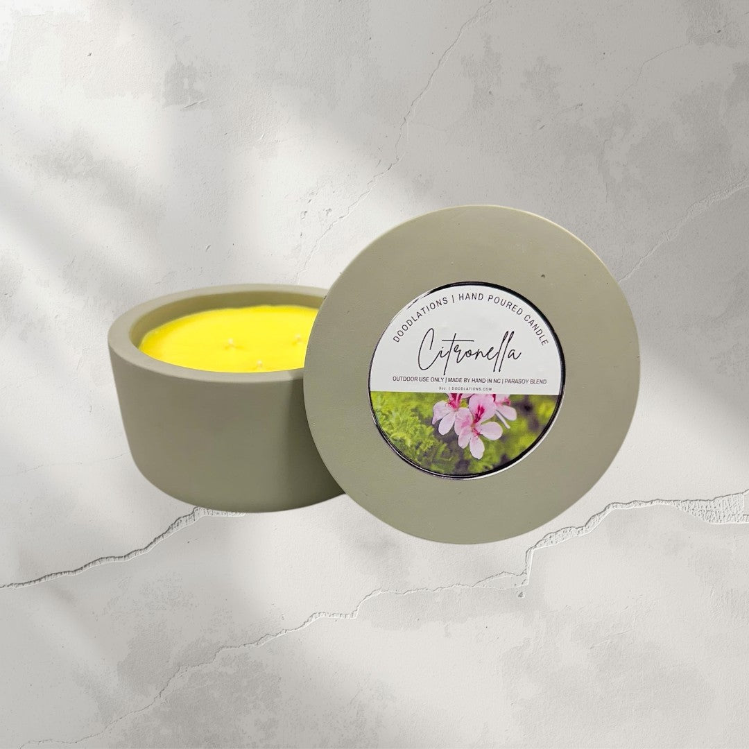 Doodlations 3-wick citronella candle in a grey concrete vessel with yellow wax. Outdoor use.