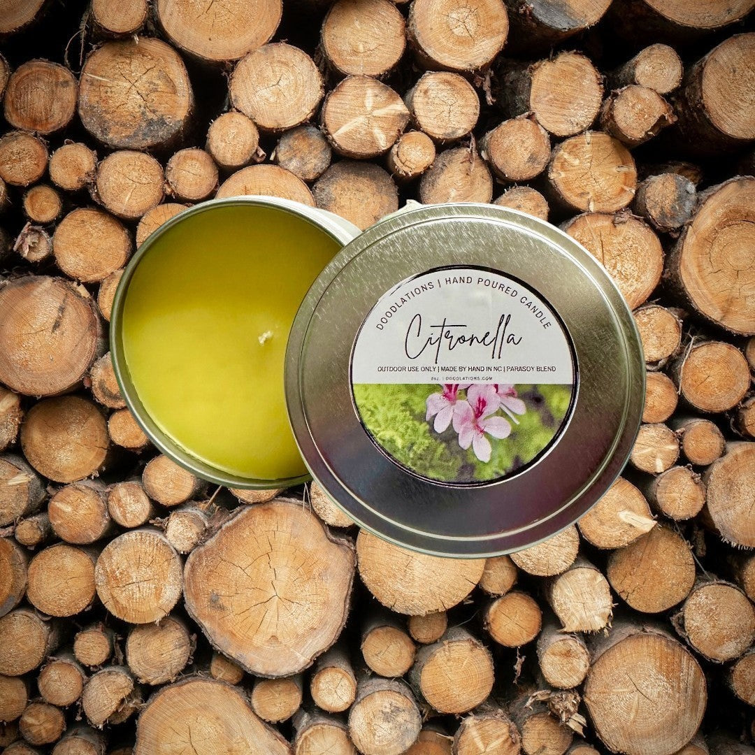 Doodlations Citronella outdoor candle in a metal tin with a yellow wax fill and a floral label.