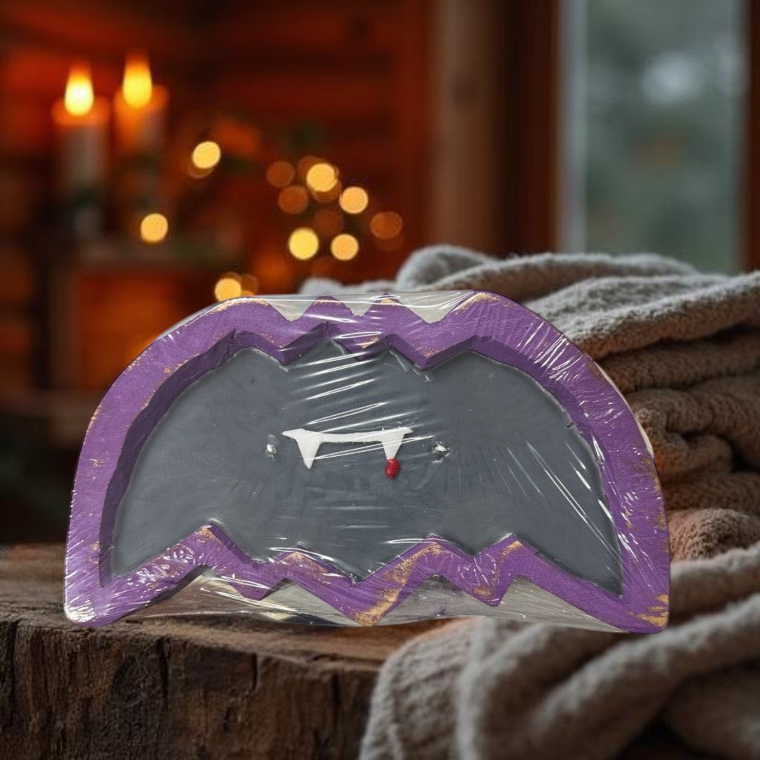 Doodlations Coffee Bar & Boutique Bat Dough Bowl Candle with fangs and a red drop, purple and gold trim.