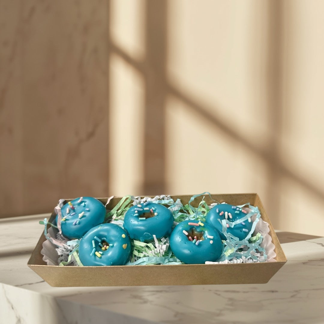 Doodlations Coffee Bar & Boutique blue glazed donut wax melts with sprinkles, surrounded by cream wax melts.
