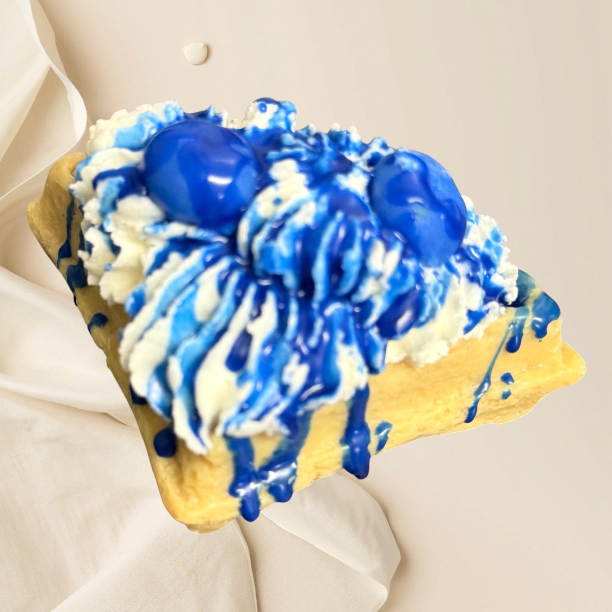 Doodlations Coffee Bar & Boutique Blueberry Waffle wax melt shaped like a waffle with whipped cream and blue syrup drizzle.