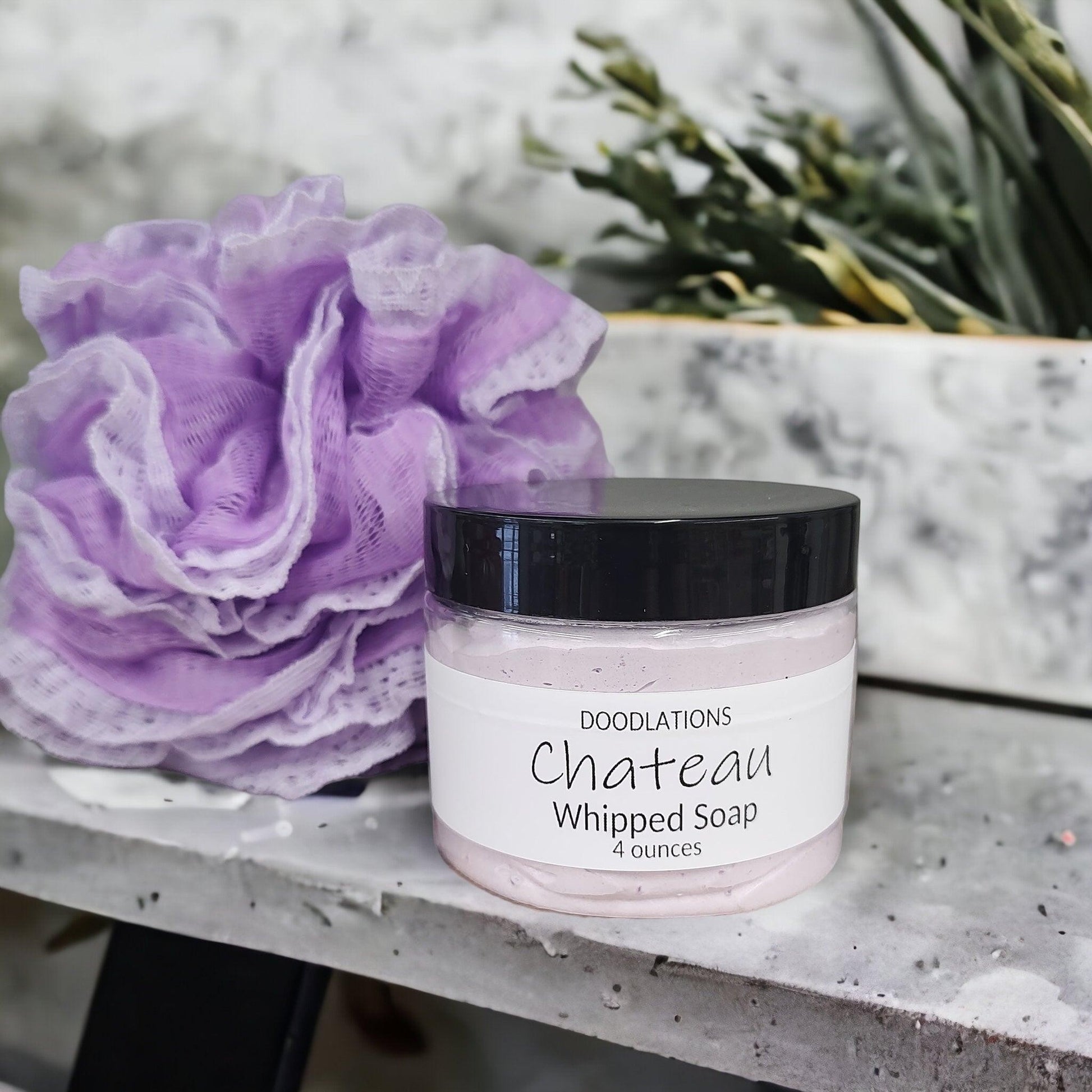 Doodlations Coffee Bar & Boutique Chateau whipped soap in a 4oz jar with a grape scent and purple bath loofah.