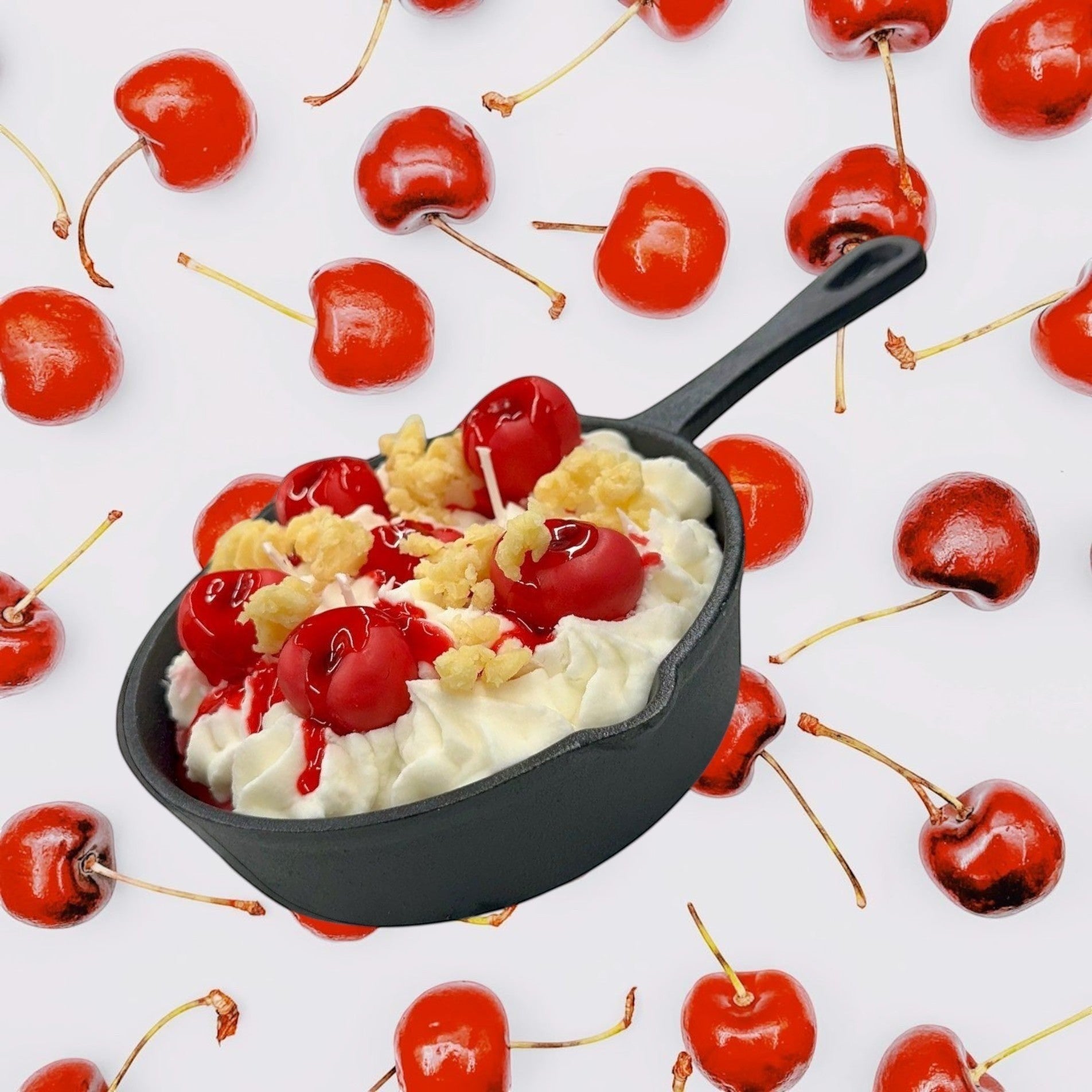 Doodlations Coffee Bar & Boutique Cherry Yum Yum candle in a black iron skillet with white wax frosting, red wax cherries, and crumble topping.