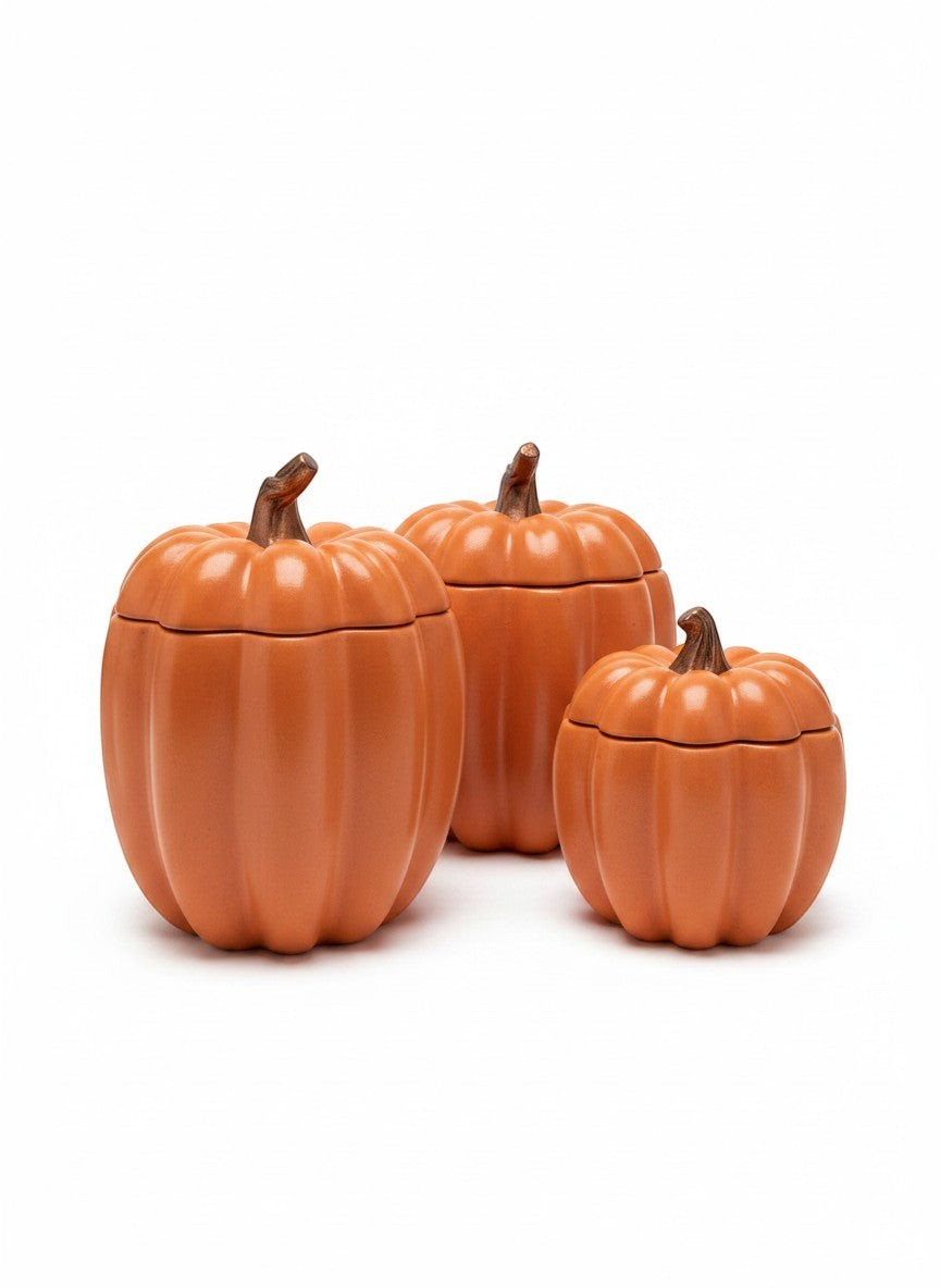 Doodlations Coffee Bar & Boutique concrete pumpkin candle vessels in three sizes, orange, with brown stems.