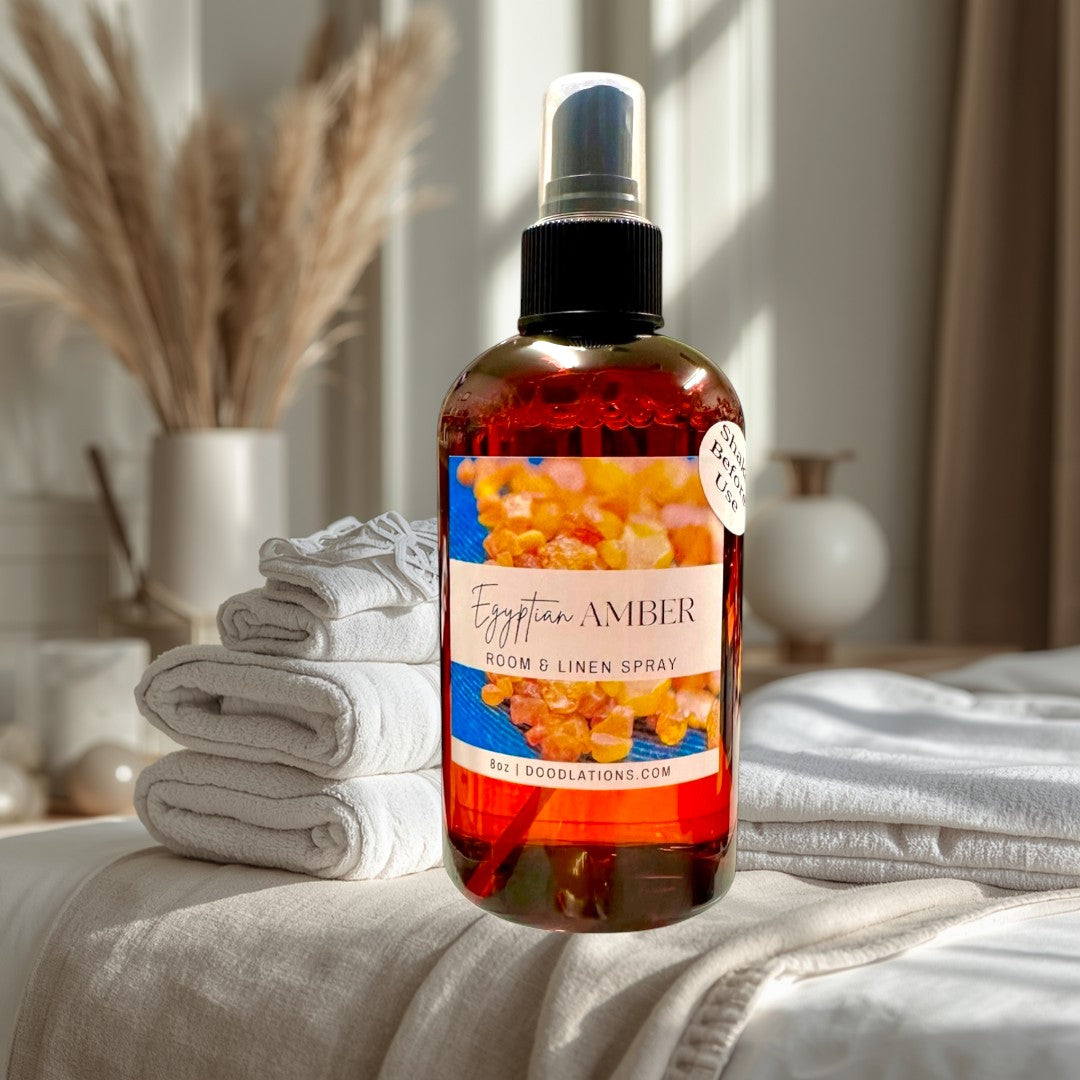 Doodlations Coffee Bar & Boutique Egyptian Amber Room & Linen Spray, 8oz amber glass bottle with spray top. Scent notes: vanilla, musk, sandalwood, citrus, amber, jasmine.