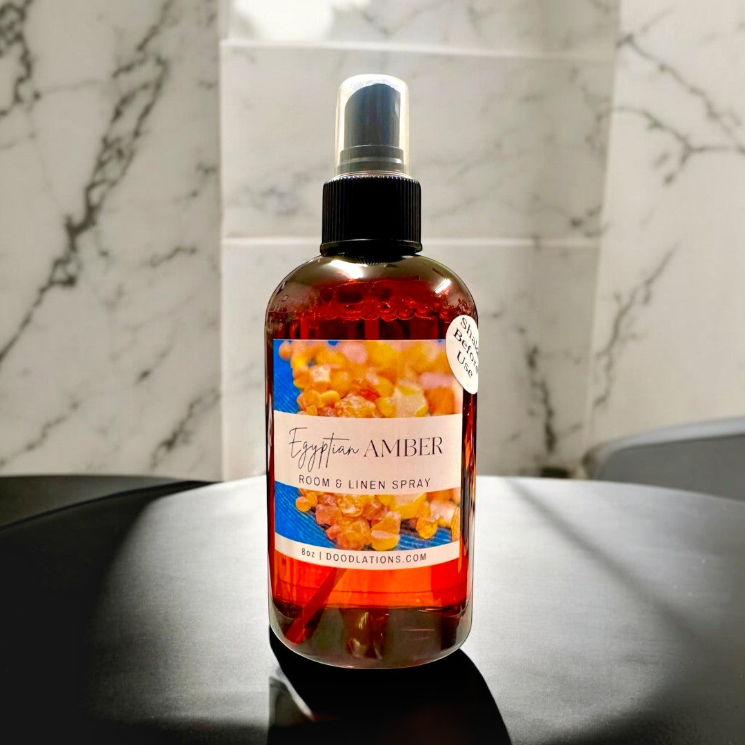 Doodlations Coffee Bar & Boutique Egyptian Amber Room & Linen Spray, 8oz amber bottle with spray top. Complex woody scent with citrus, amber, jasmine, vanilla, musk, and sandalwood.