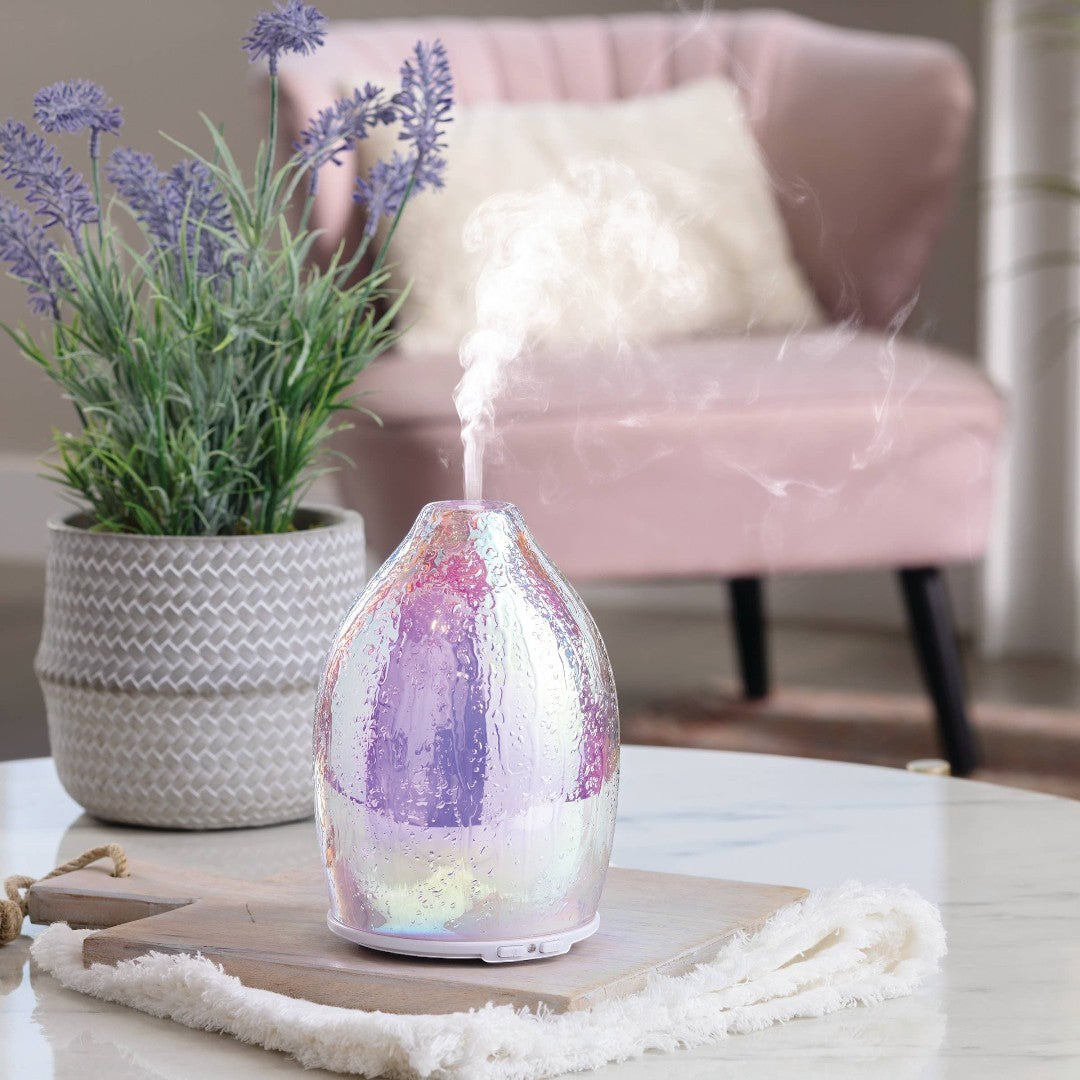 Doodlations Coffee Bar & Boutique iridescent water droplet aroma diffuser with textured glass emitting mist.