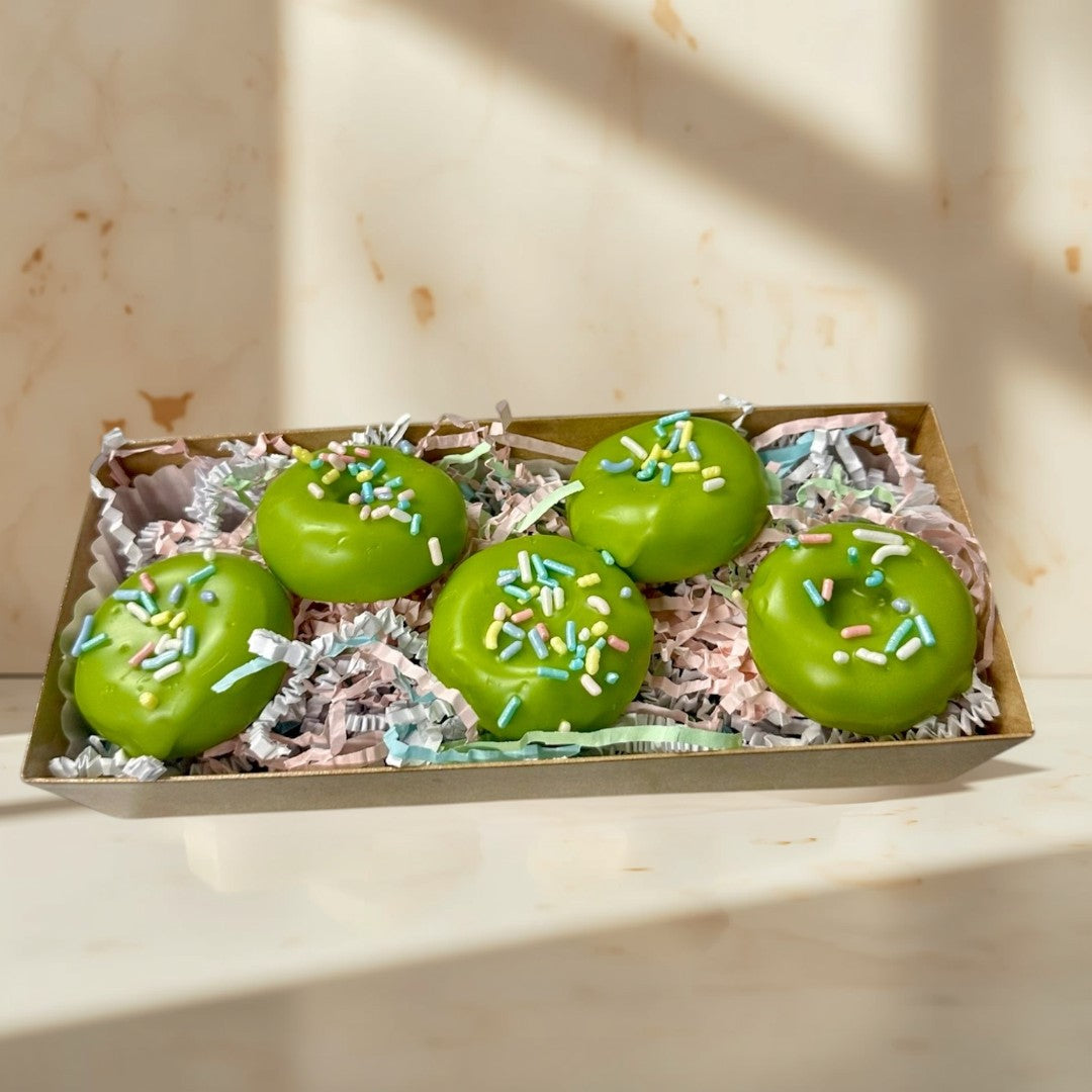 Doodlations Coffee Bar & Boutique Key Lime Donut wax melts are bright green and shaped like donuts with colorful sprinkles.