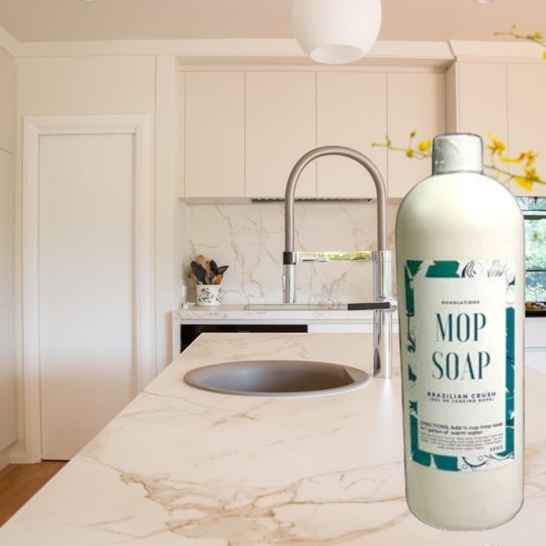 Doodlations Coffee Bar & Boutique Brazilian Crush concentrated mop soap in a white bottle with a teal label.