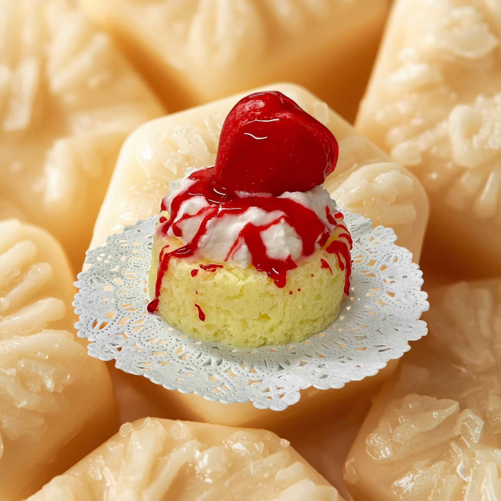 Doodlations Coffee Bar & Boutique Strawberry Shortcake wax melt designed to look like a mini cake with whipped cream and strawberry drizzle.