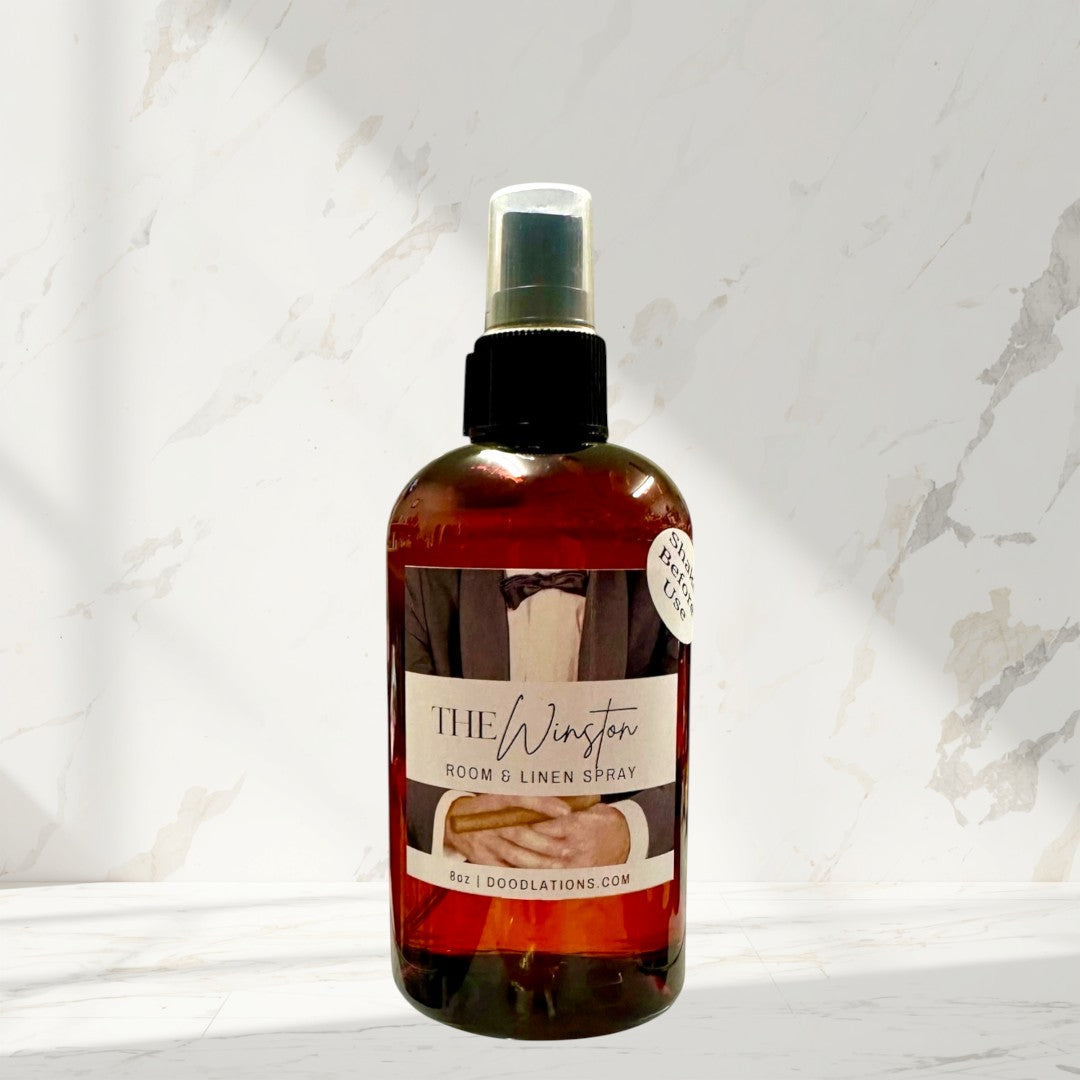 Doodlations Coffee Bar & Boutique The Winston room & linen spray in amber glass bottle with black spray top.