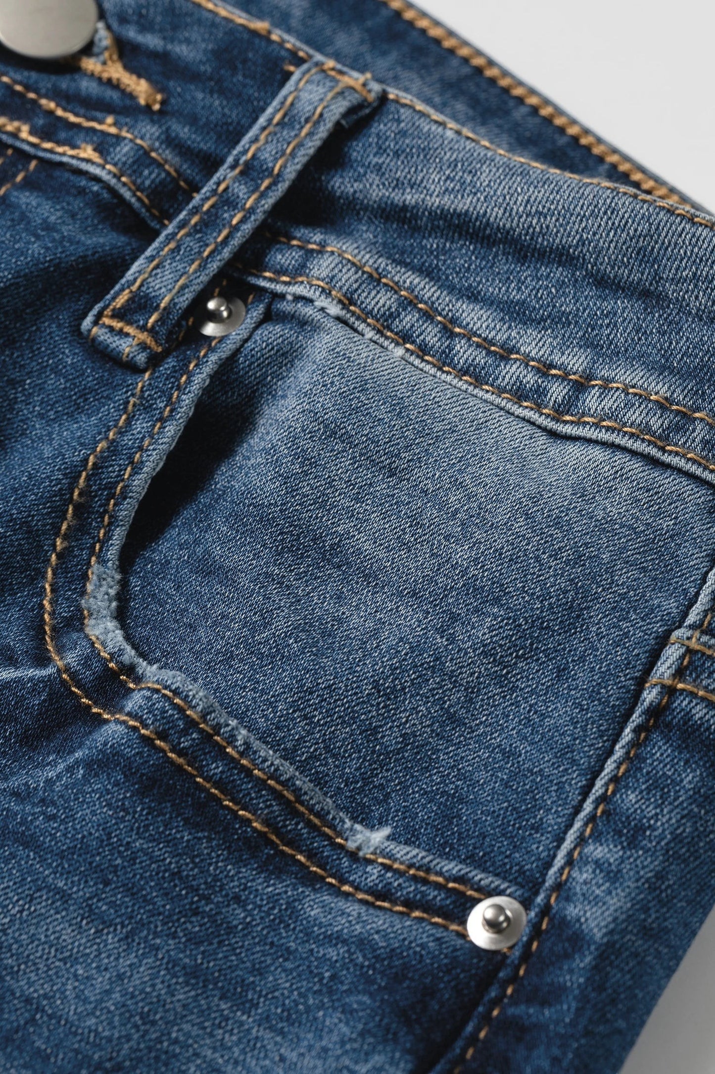 Doodlations Coffee Bar & Boutique blue acid washed denim jeans featuring contrast stitching and a front pocket detail.