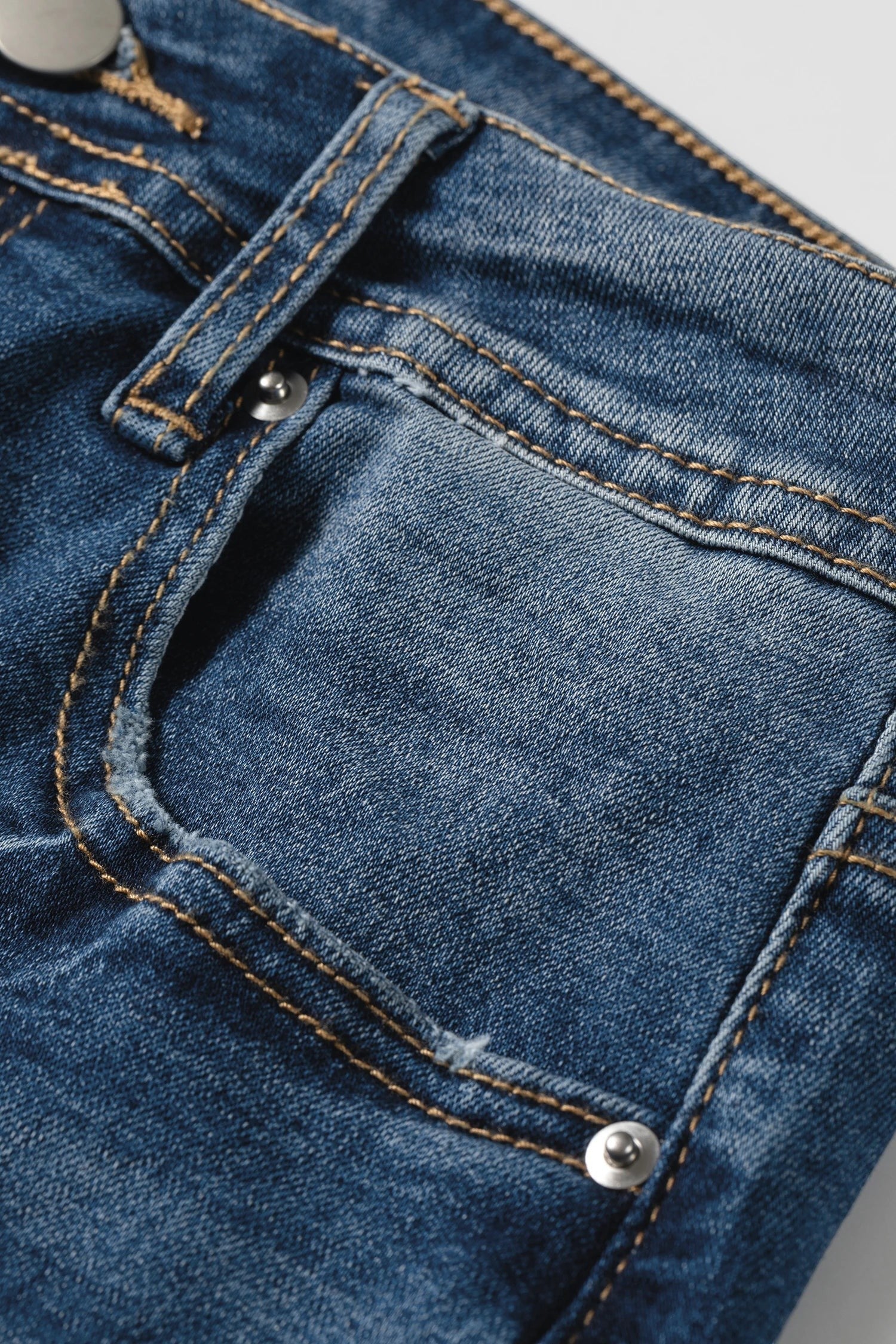 Doodlations Coffee Bar & Boutique blue acid washed denim jeans featuring contrast stitching and a front pocket detail.