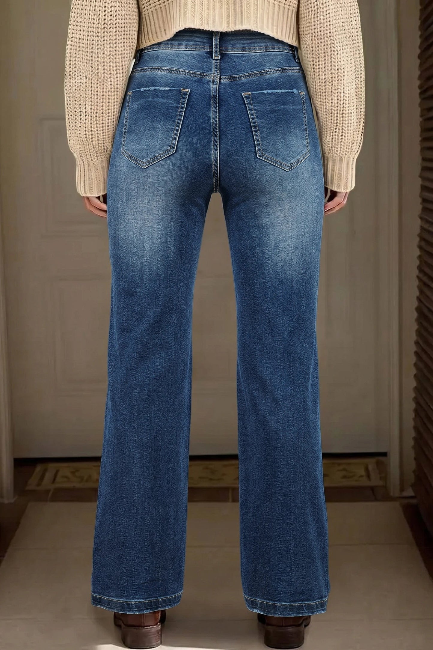 Back view of Doodlations Coffee Bar & Boutique acid-washed blue straight leg jeans worn with a beige sweater