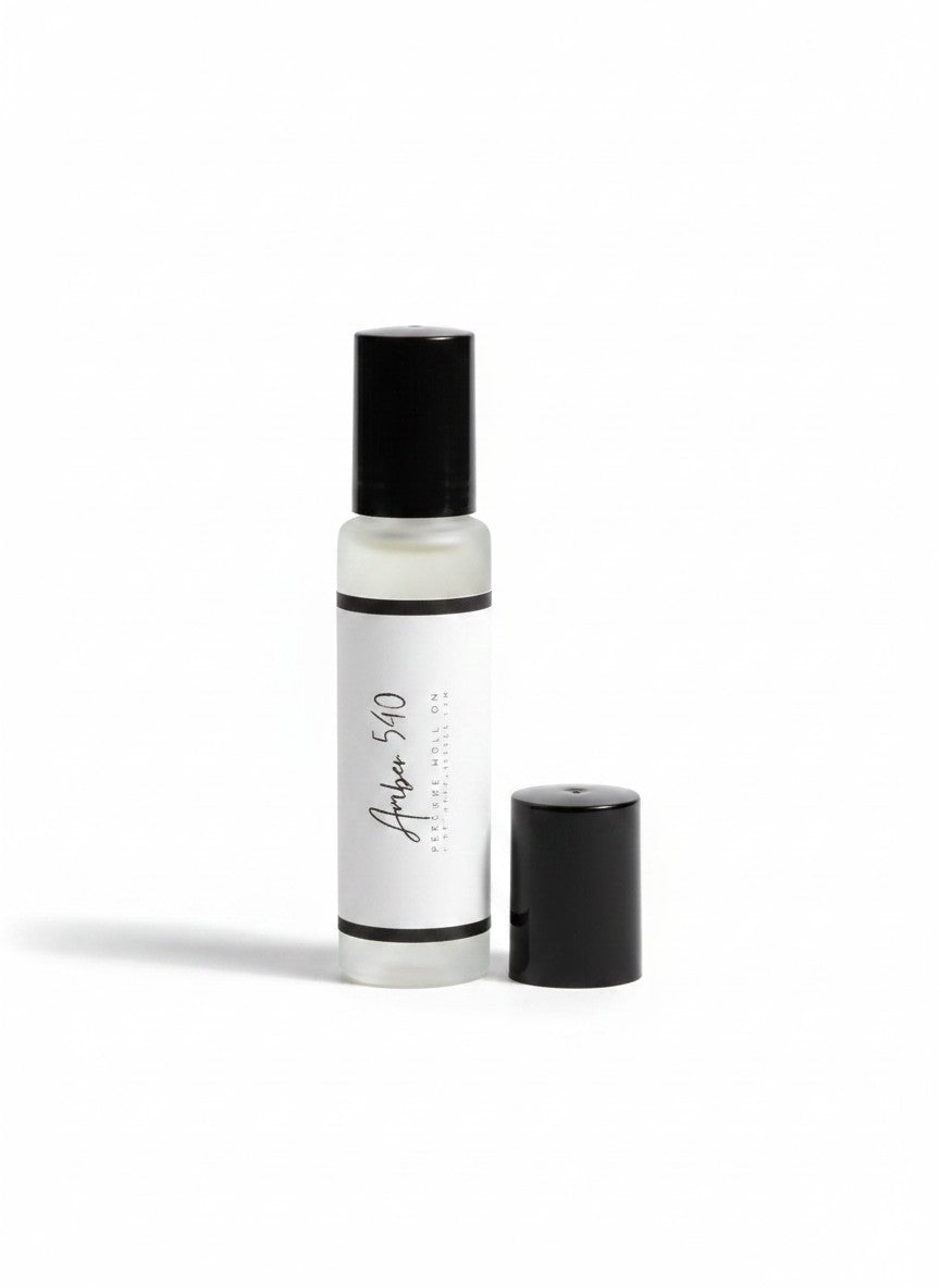 Doodlations Coffee Bar & Boutique Amber 540 luxury roll-on perfume in a sleek glass bottle with a black cap.