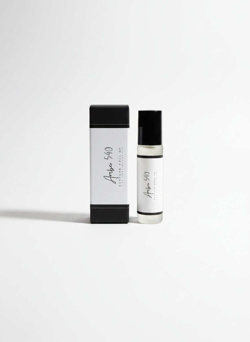 Doodlations Coffee Bar & Boutique Amber 540 luxury roll-on perfume in a sleek glass bottle with matching box.