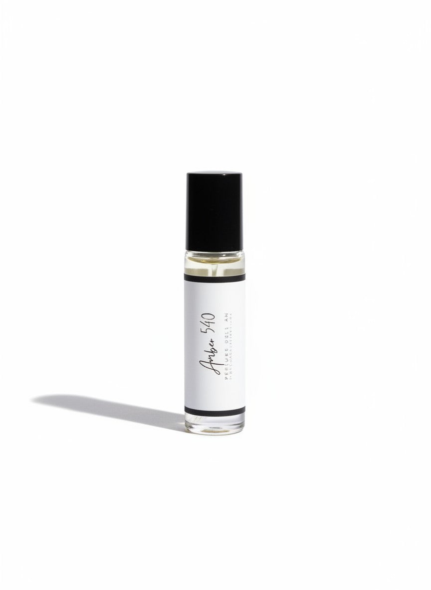 Doodlations Coffee Bar & Boutique Amber 540 luxury roll-on perfume in a sleek glass bottle with a black cap.