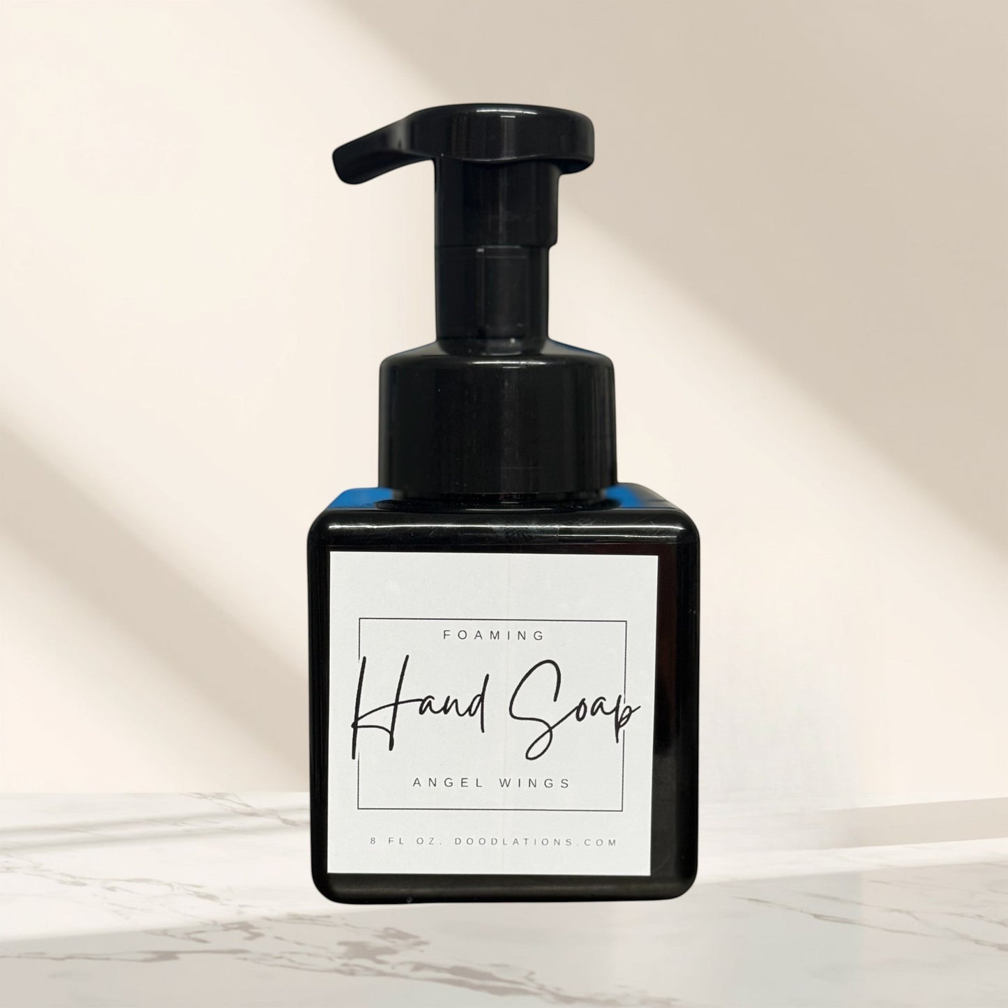 Doodlations Coffee Bar & Boutique Angel Wings foaming hand soap in a black bottle with a white label.
