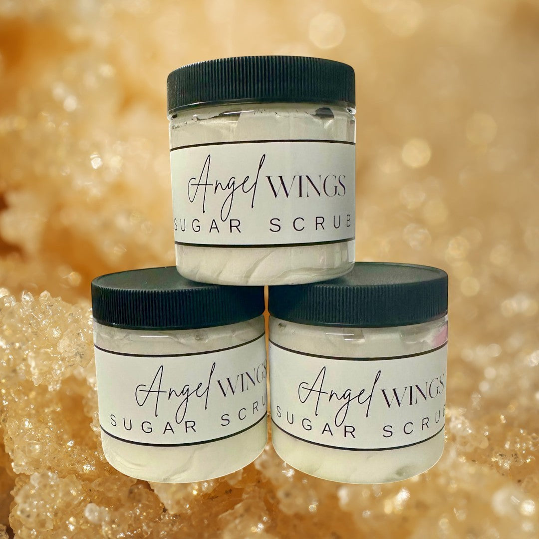 Doodlations Coffee Bar & Boutique Angel Wings sugar scrub in clear jars with black lids. White scrub with flecks of color.