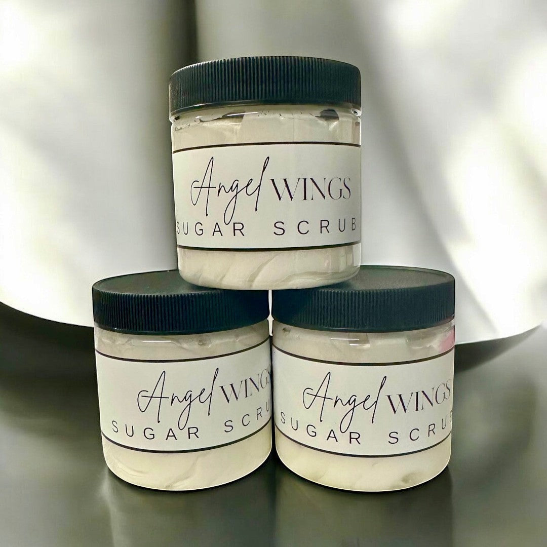 Doodlations Coffee Bar & Boutique Angel Wings sugar scrub in clear jars with black lids. Gentle exfoliation for smooth, nourished skin.