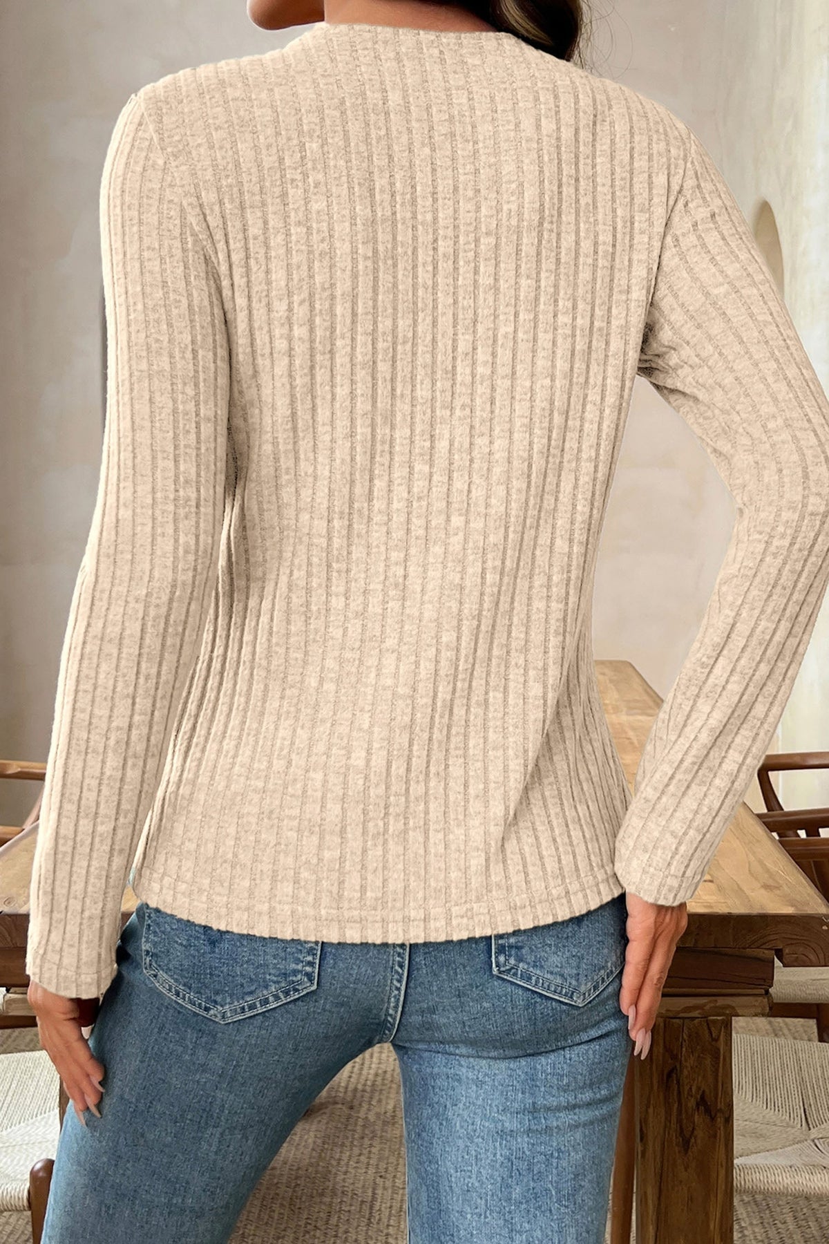 Back view of Doodlations Coffee Bar & Boutique apricot ribbed knit long sleeve top worn with blue denim jeans
