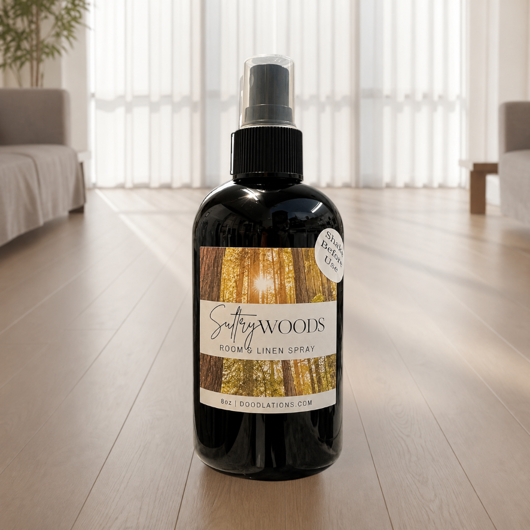 Doodlations Coffee Bar & Boutique Autumn Flannel room and linen spray in a black bottle with a forest-themed label.