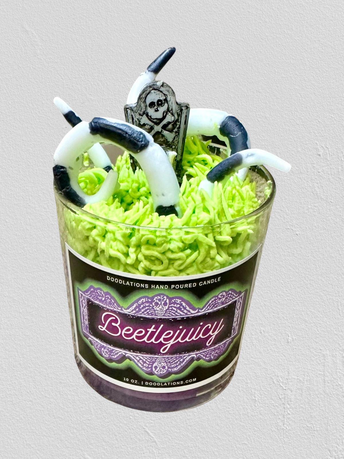 Doodlations Coffee Bar & Boutique Beetlejuicy luxury candle with wax sandworm and tombstone details in a glass jar.