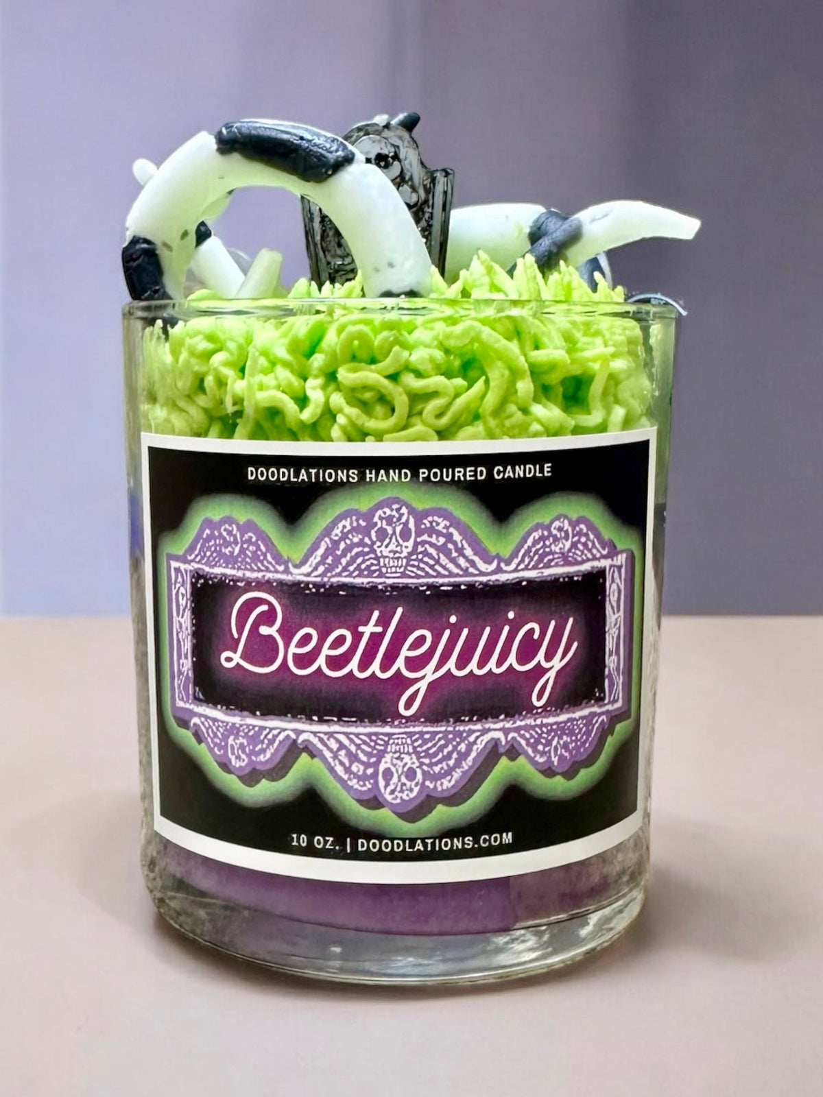 Doodlations Coffee Bar & Boutique Beetlejuicy luxury candle with green wax sandworm details in a glass jar