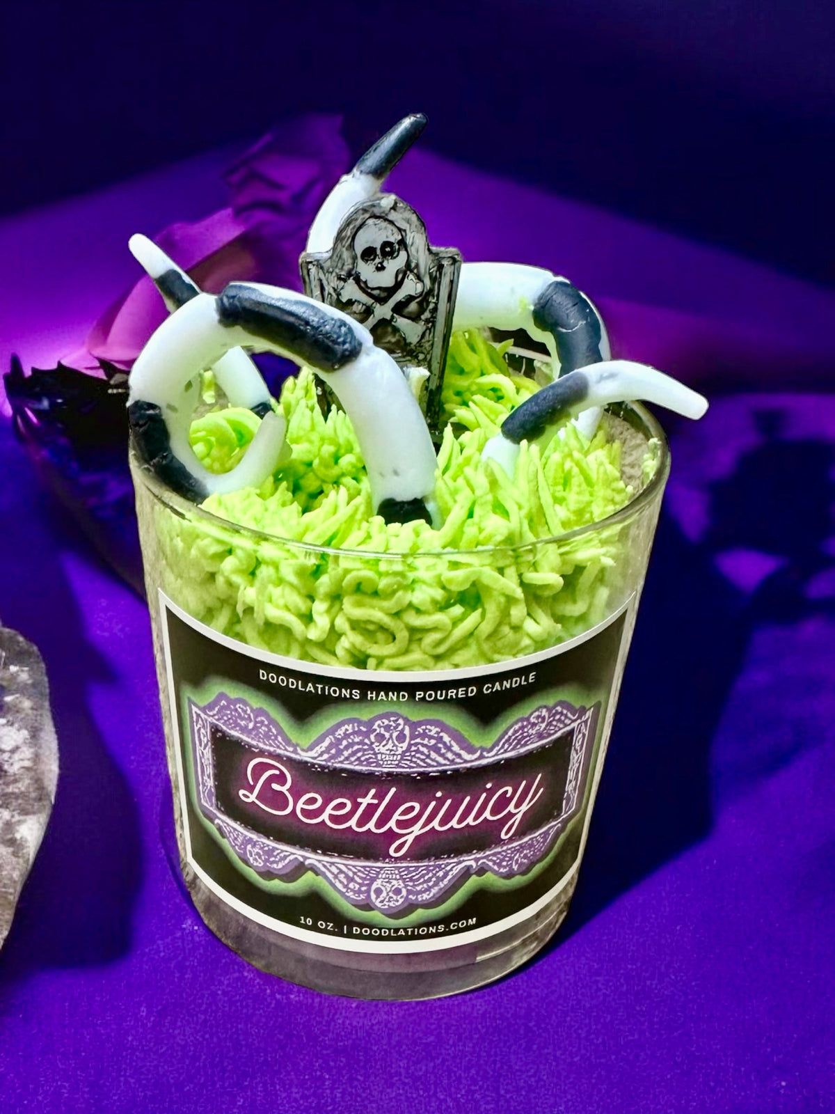 Doodlations Coffee Bar & Boutique Beetlejuicy luxury candle with wax sandworm and tombstone decor on purple background