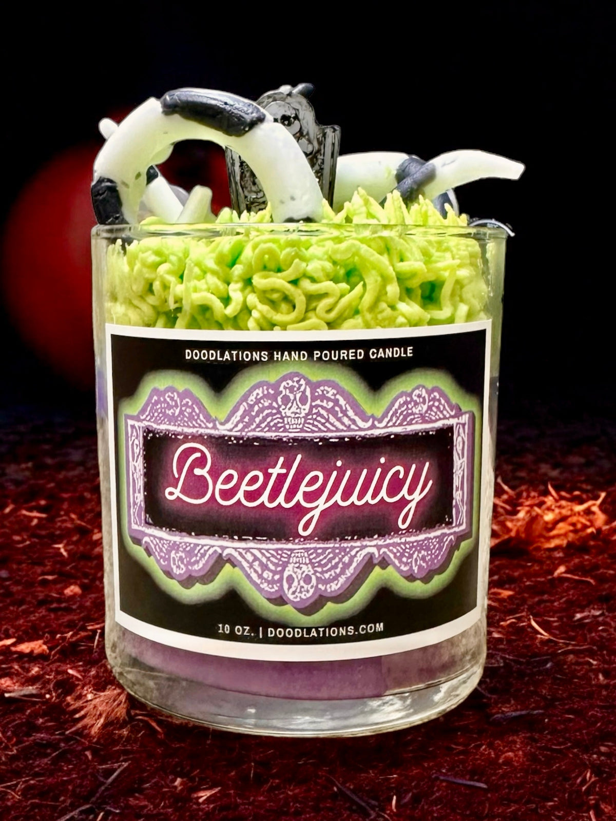 Doodlations Coffee Bar & Boutique Beetlejuicy luxury candle with green wax sandworm details and a spooky label.