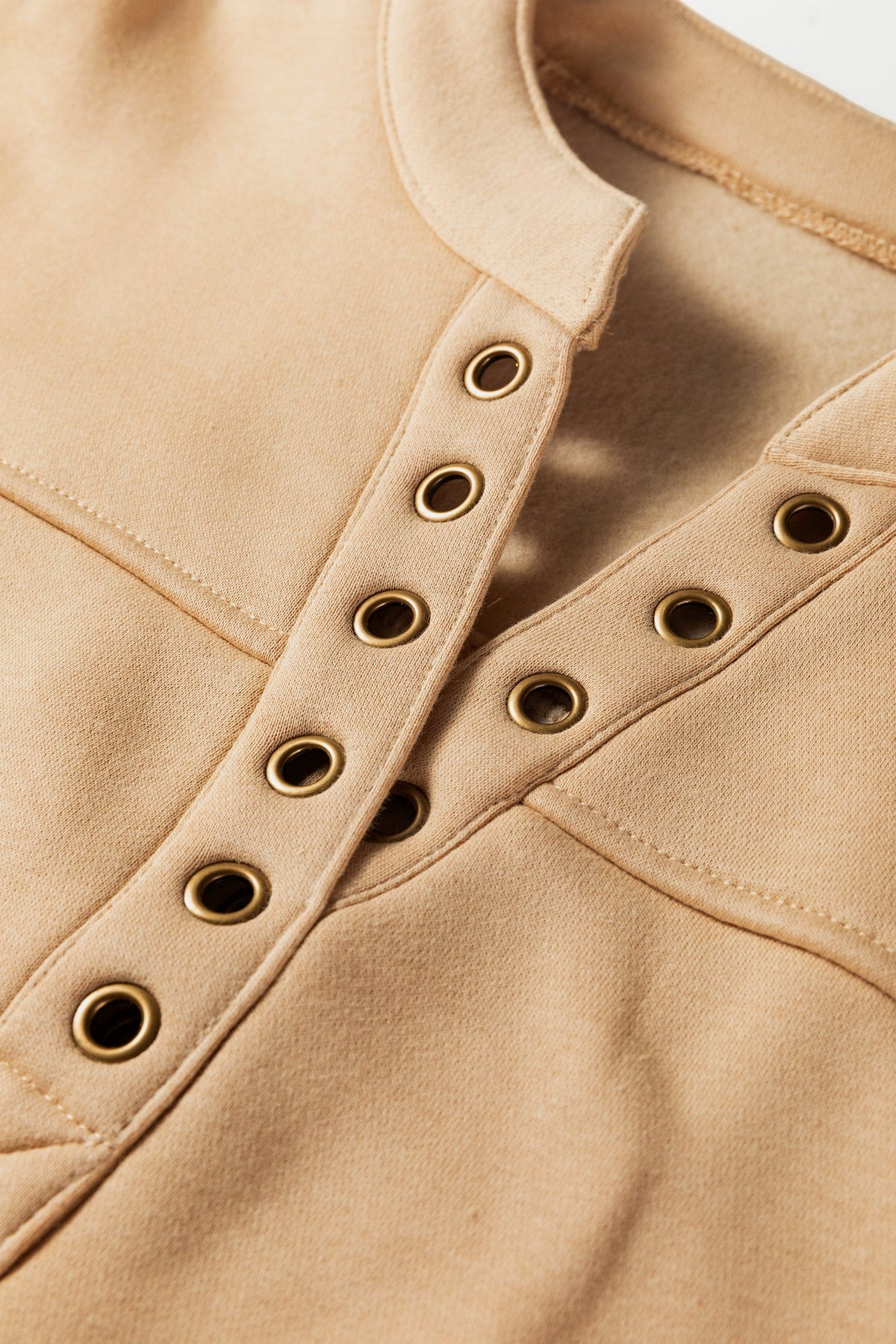 Doodlations Coffee Bar & Boutique light beige V-neck sweatshirt featuring metallic grommet neckline details
