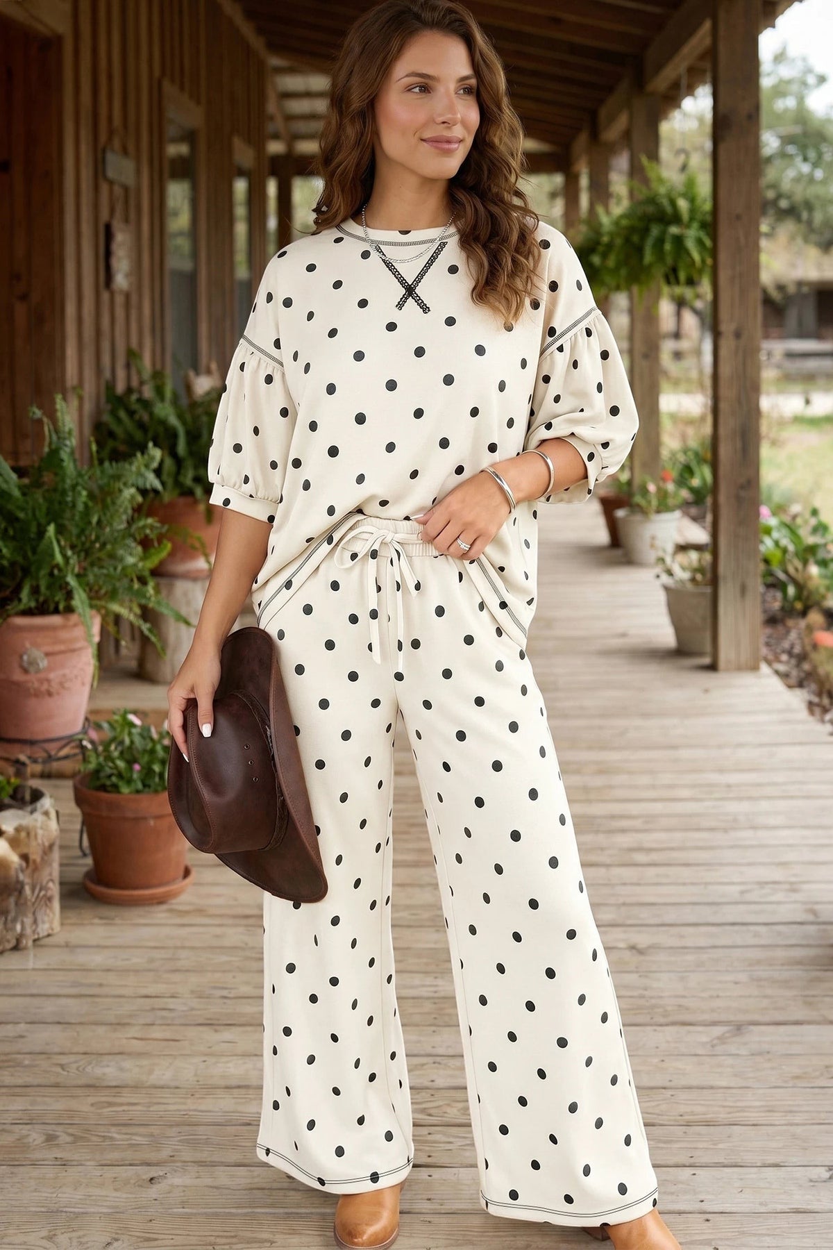 Woman wearing a Doodlations Coffee Bar & Boutique beige polka dot loose top and matching elastic waist casual pants.