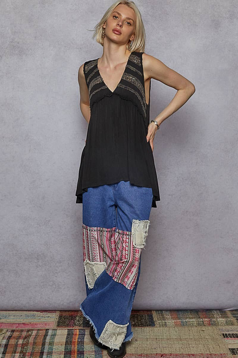 Doodlations Coffee Bar & Boutique black sleeveless babydoll knit top with lace trim, V-neck, and ruffled details.
