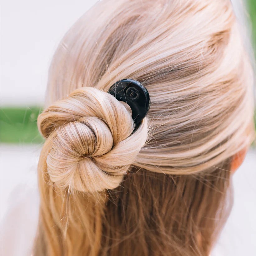 Doodlations Coffee Bar & Boutique Teleties French hair pin in black securing a blonde hair bun for a polished updo