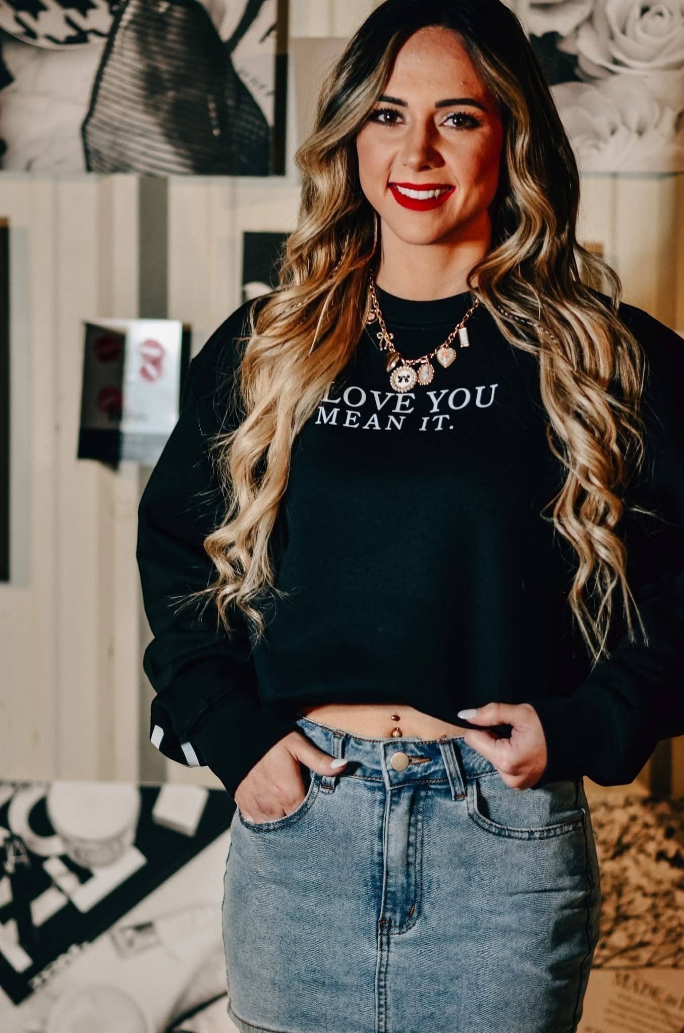 Woman wearing Doodlations Coffee Bar & Boutique black crew neck sweatshirt with Love You Mean It graphic text