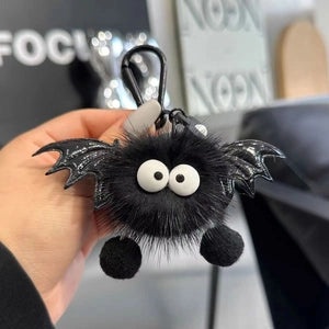 Doodlations Coffee Bar & Boutique plush black bat bag charm with faux fur, googly eyes, and shiny wings on a clasp