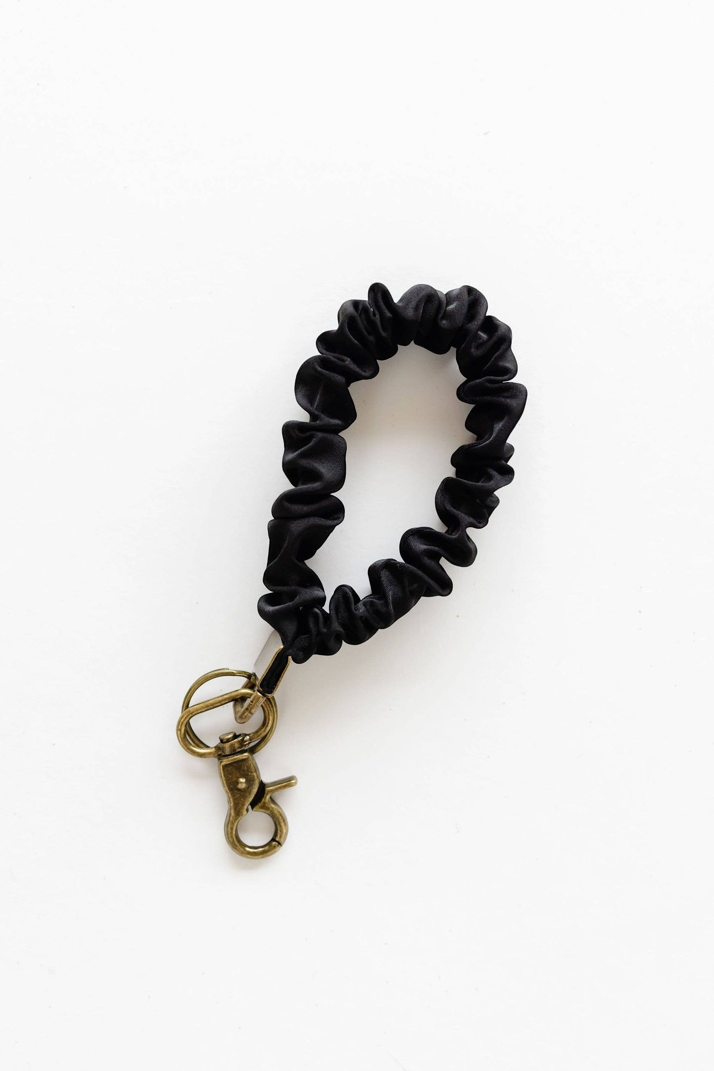 Doodlations Coffee Bar & Boutique black luxe satin scrunchie keychain with a brass clasp on a white background