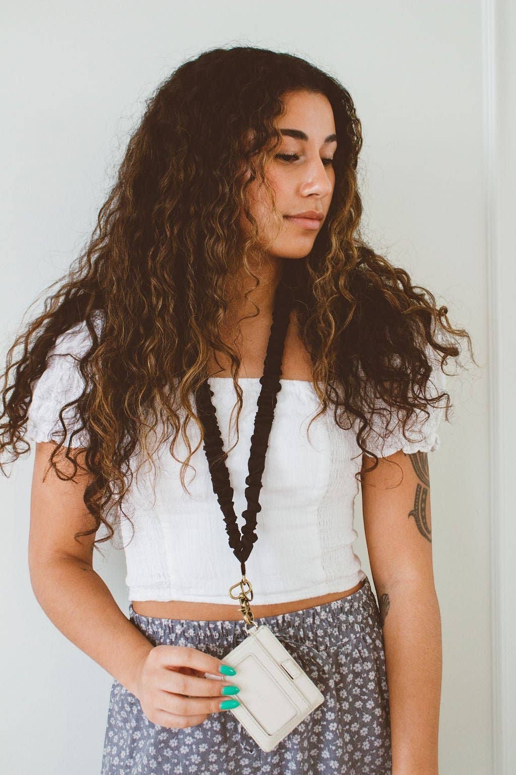 Doodlations Coffee Bar & Boutique black silky sateen scrunchie lanyard worn by a woman with long curly hair