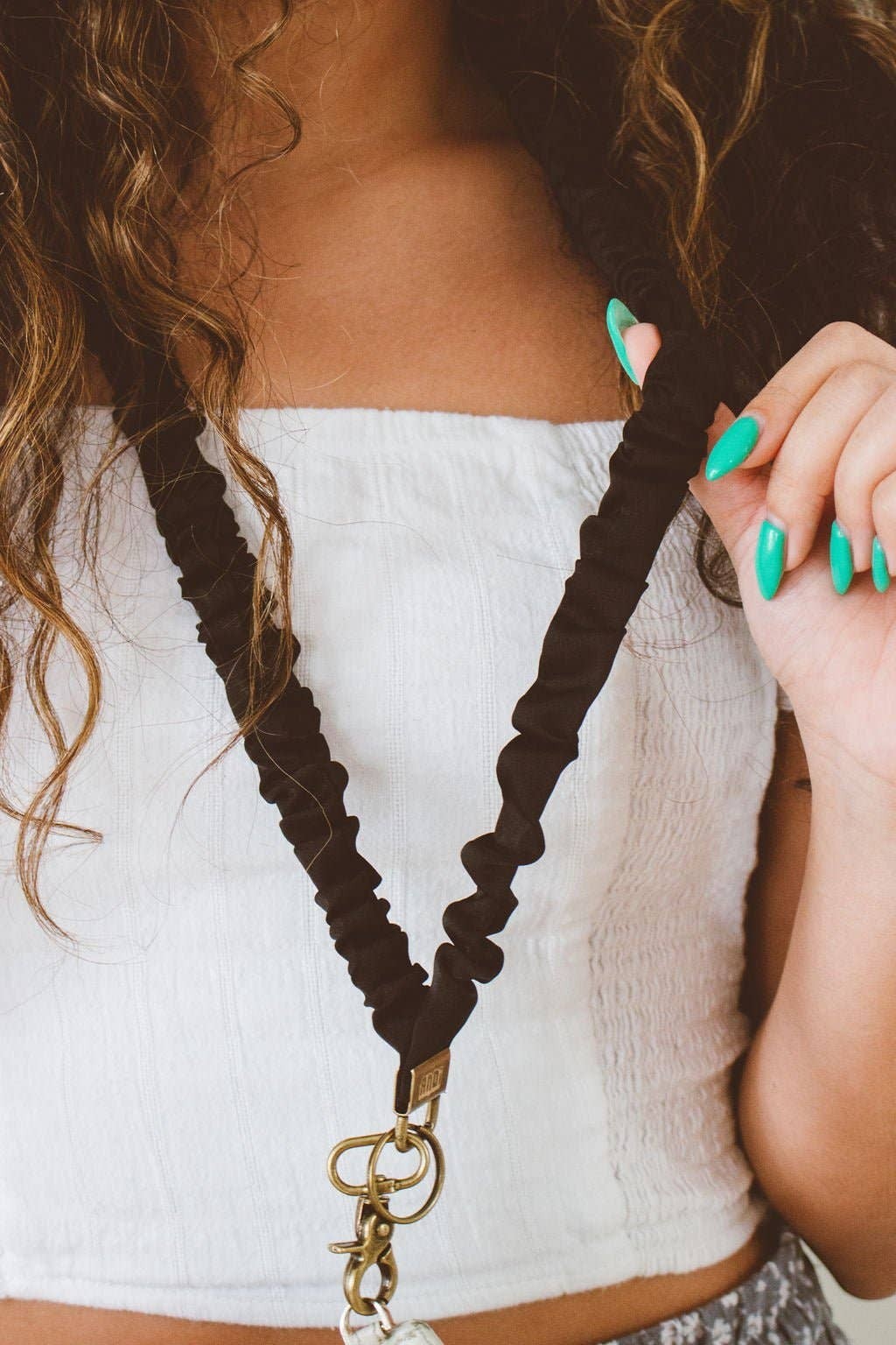 Doodlations Coffee Bar & Boutique black scrunchie lanyard made of silky sateen fabric worn around a woman's neck