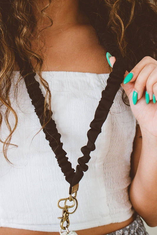 Doodlations Coffee Bar & Boutique black scrunchie lanyard made of silky sateen fabric worn around a woman's neck