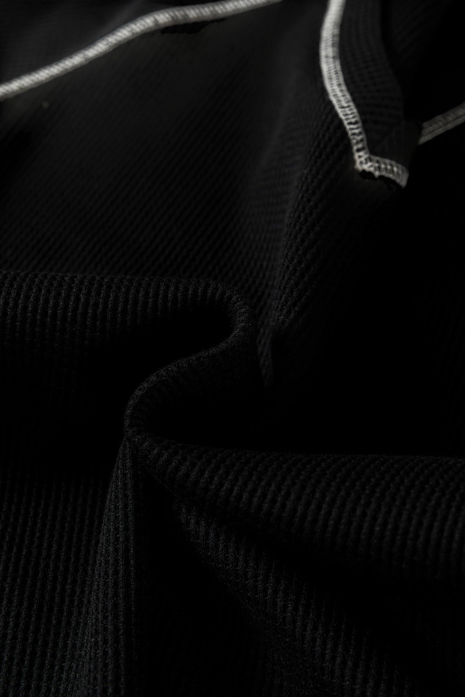 Doodlations Coffee Bar & Boutique black waffle knit top featuring a V-neckline and white contrast stitch detailing.