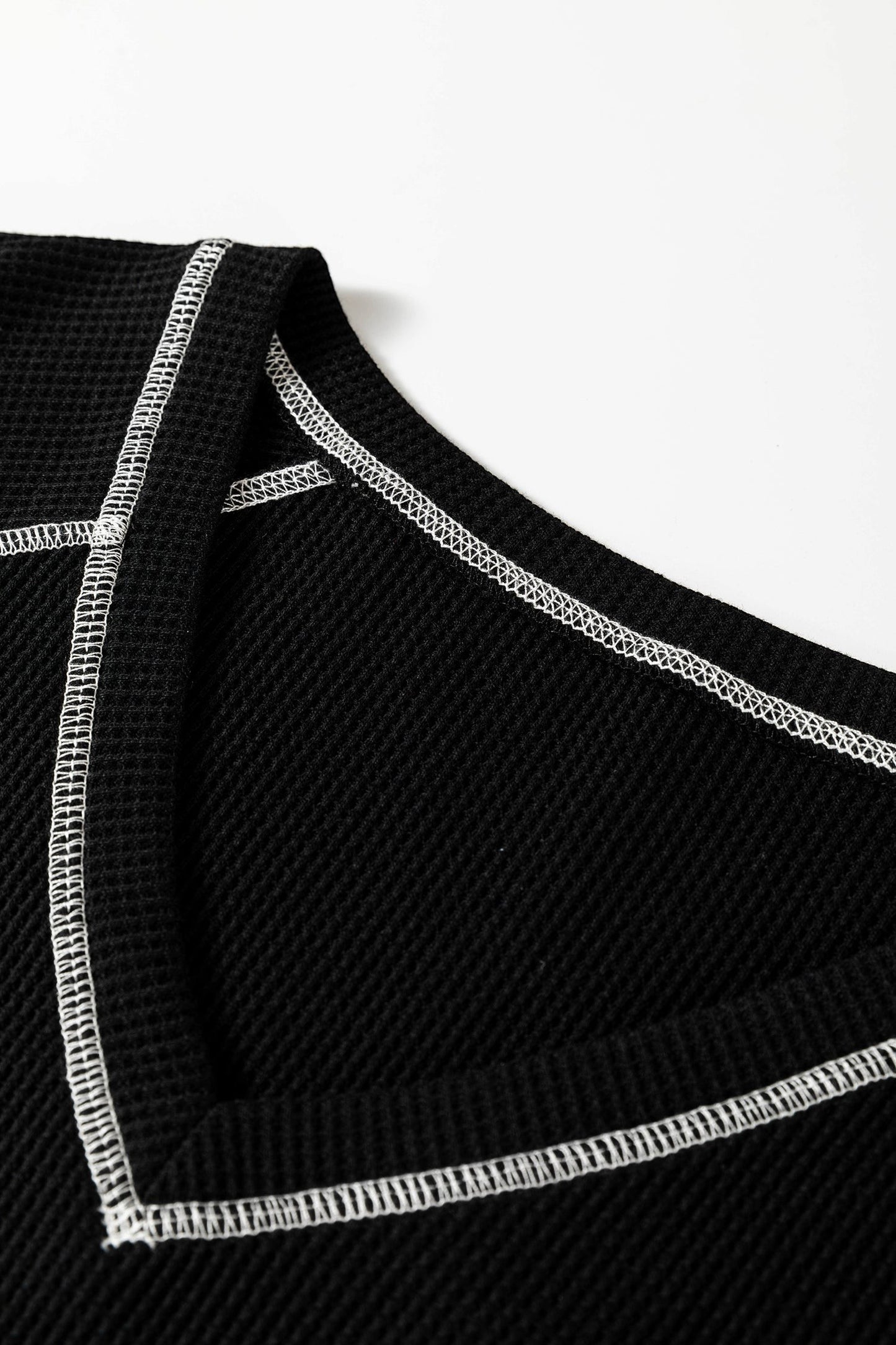 Doodlations Coffee Bar & Boutique black waffle knit V-neck top featuring white contrast stitching detail.